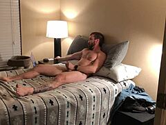 Um homem musculoso com tatuagens apanha-se a masturbar-se