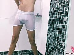 18letý gay si užívá horkou sprchu v bílém oblečení