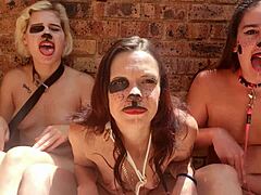 세 명의 벗은 여성들이 야외에서 기묘한 혀놀이를 합니다